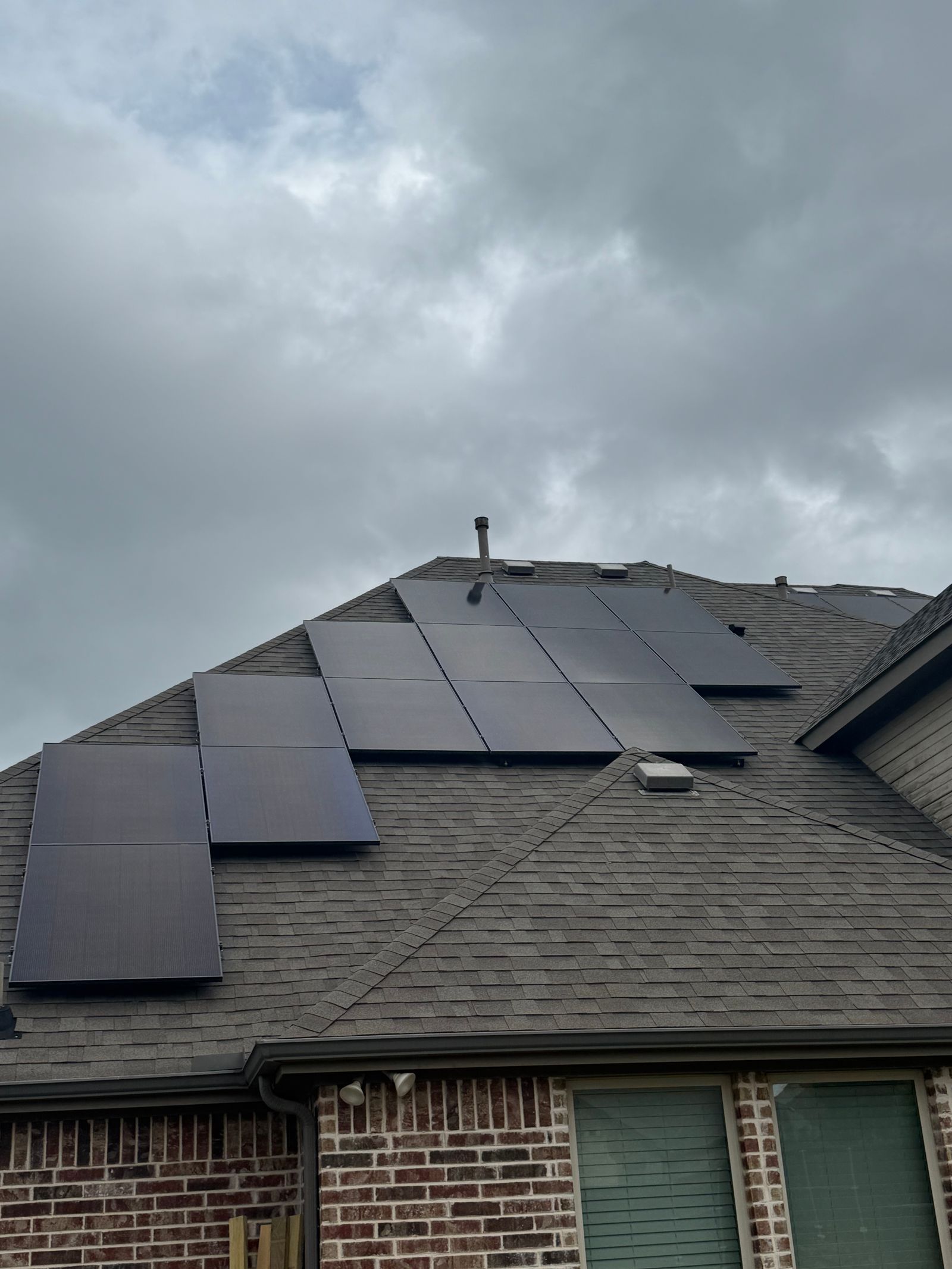 Close-up of solar panels on residential brick home rooftop